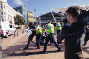 A protestor is led away. Photo by Nick Tapp.