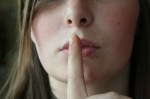 woman with finger to lips indicating shhh secret