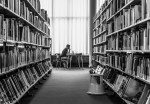 a seated person reading at the library