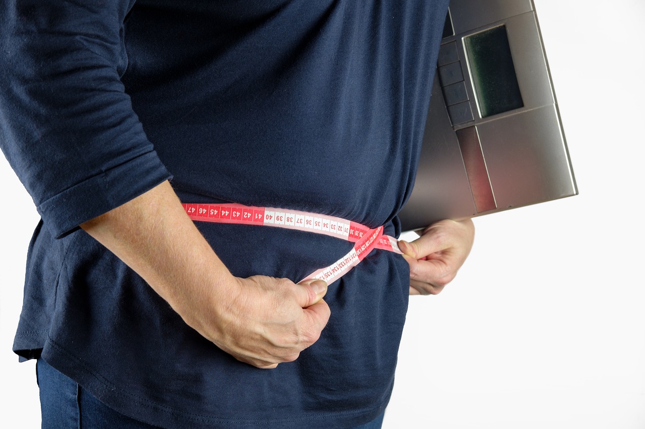 person measuring waistline