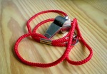 A metal whistle on a red cord